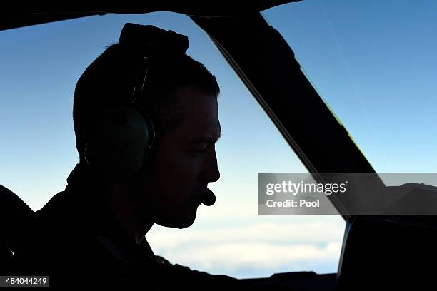 Royal New Zealand Air Force Captain Flight Lieutenant Timothy McAlevey sits in the cockpit aboard a P3 Orion maratime search aircraft as it flies...