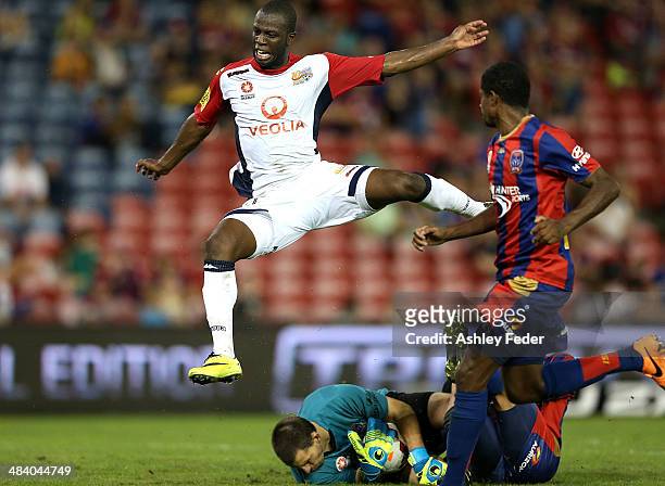 Bruce Djite of Adelaide United leaps over goalkeeper Ben Kennedy of the Jets during the round 27 A-League match between the Newcastle Jets and...