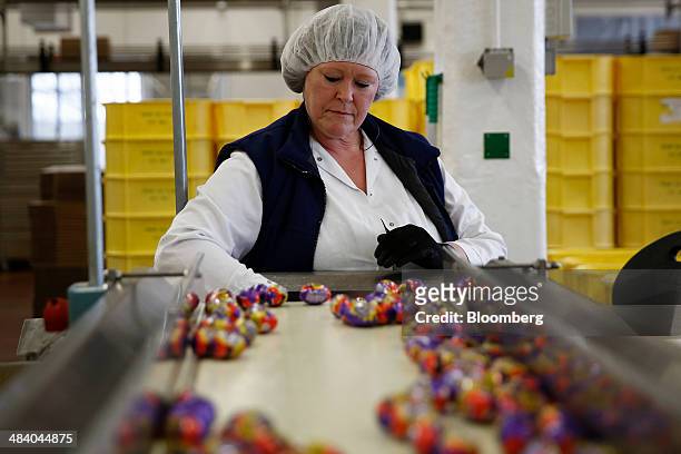 An employee monitors foil-wrapped Cadbury Creme Eggs as they move along the production line at the Bournville Cadbury factory, operated by Mondelez...