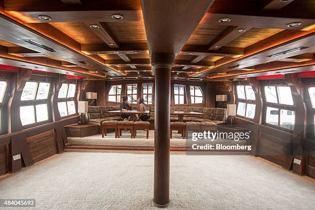 Visitors sit in the grand salon of the Royal Albatross tall ship, operated by Tall Ship Adventures Pte, at the Singapore Yacht Show in Singapore, on...