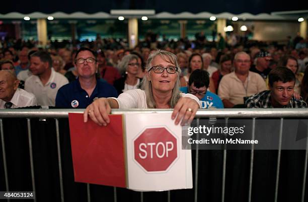 The official timer holds up a sign indicating Democratic presidential candidate Martin O'Malley spoke longer than his allotted 20 minutes at the Iowa...