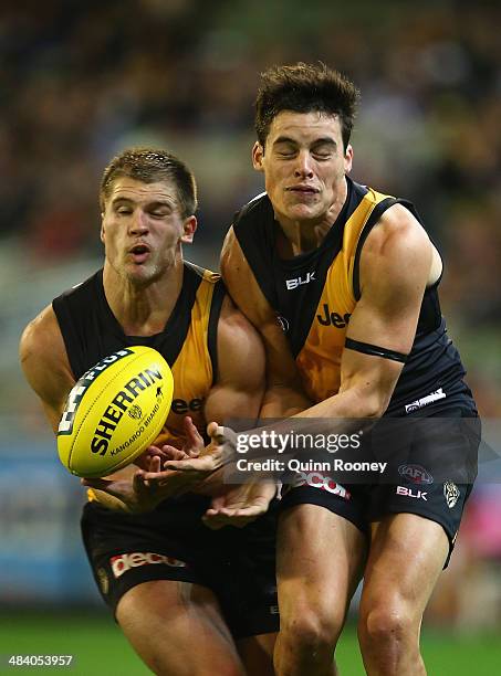 Matt Arnot and Nathan Gordon of the Tigers bump into each other as they both go for a mark during the round four AFL match between the Richmond...