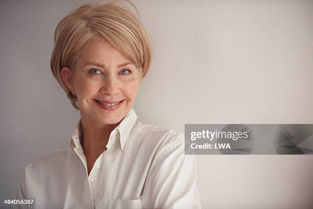 smiling mature woman - female blonde blue eyes stock pictures, royalty-free photos & images