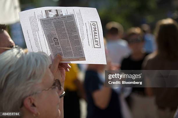 An attendee shades herself with a Martin O'Malley, former governor of Maryland and 2016 Democratic presidential candidate, campaign pamphlet outside...