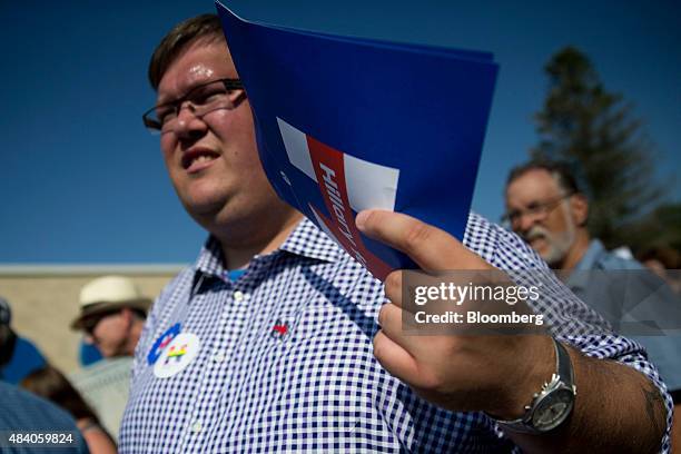 An attendee fans himself with a Hillary Clinton, former U.S. Secretary of state and 2016 Democratic presidential candidate, campaign sign outside the...