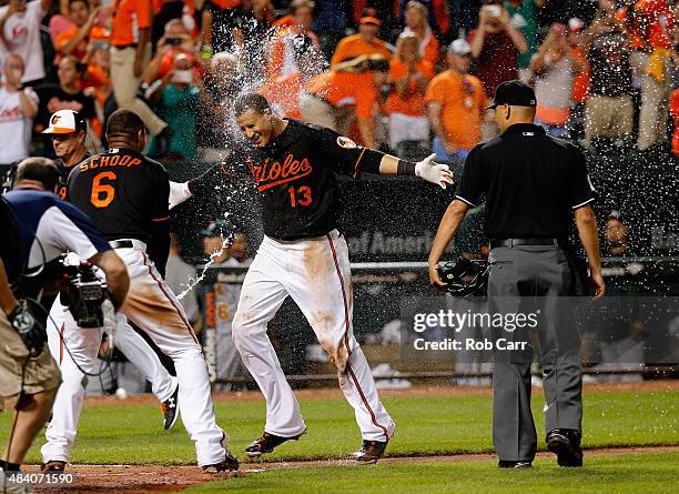 Manny Machado of the Baltimore Orioles is sprayed with water by teammate Jonathan Schoop after hitting a two RBI walk off home run against the...