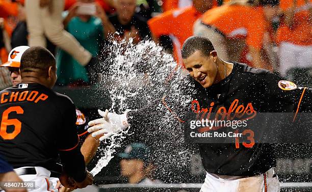 Manny Machado of the Baltimore Orioles is sprayed with water by teammate Jonathan Schoop after hitting a two RBI walk off home run against the...