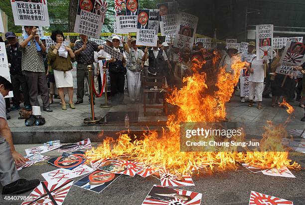 South Korean protesters burn anti-Japan placards during a protest as South Korea marks the 70th Independence Day in front of Japanese embassy on...