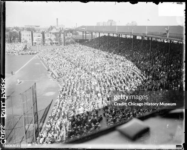 Crowds sitting and standing in the grandstands along the first baseline at Wrigley Field, located at 1060 West Addison Street, Chicago, Illinois,...