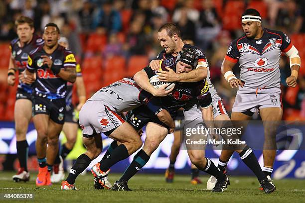 Nigel Plum of the Panthers is tackled during the round 23 NRL match between the Penrith Panthers and the New Zealand Warriors at Pepper Stadium on...