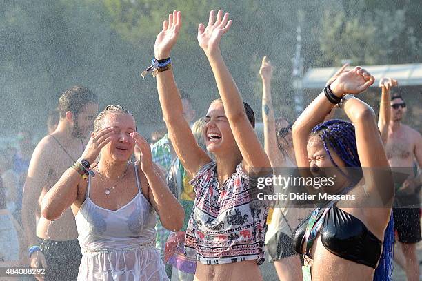 Festival goers dance under a refreshing water spray in front of the main stage at Sziget festival at Obudai Island on August 14, 2015 in Budapest,...