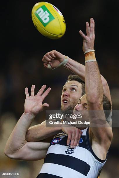 James Frawley of the Hawks punches the ball away from Josh Walker of the Cats during the round 20 AFL match between the Geelong Cats and the Hawthorn...