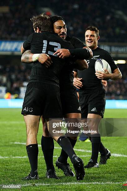 Conrad Smith of the All Blacks is congratulated by teammates Ma'a Nonu and Daniel Carter during The Rugby Championship, Bledisloe Cup match between...