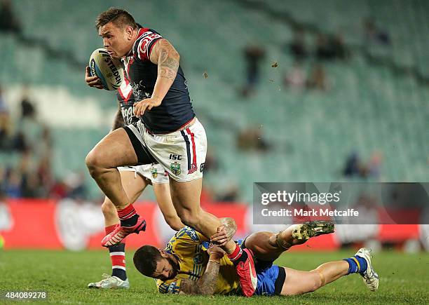 Jared Waerea-Hargreaves of the Roosters breaks through the tackle of Nathan Peats of the Eels to score a try during the round 23 NRL match between...