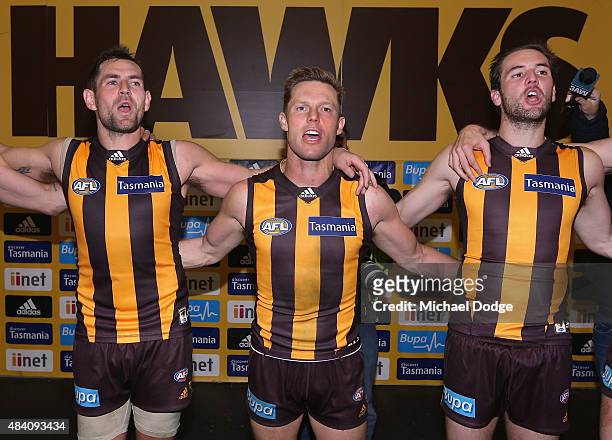 Luke Hodge of the Hawks and Sam Mitchell and Matt Suckling of the Hawks of the Hawks celebrate the win during the round 20 AFL match between the...
