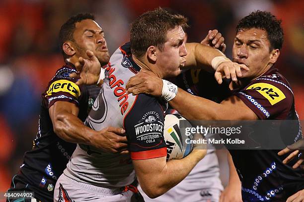 Ryan Hoffman of the warriors is tackled by Apisai Koroisau and Elijah Taylor of the Panthers during the round 23 NRL match between the Penrith...