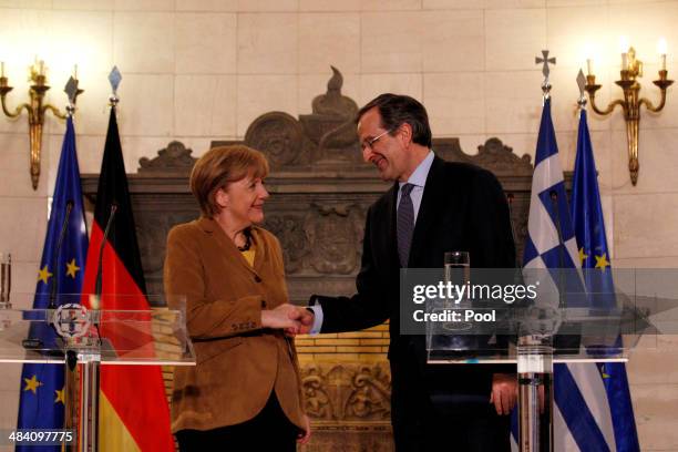 German Chancellor Angela Merkel shakes hands with Greek Prime Minister Antonis Samaras after a news conference following their meeting on April 11,...