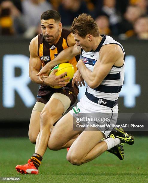 Paul Puopolo of the Hawks and Jackson Thurlow of the Cats in action during the 2015 AFL round 20 match between the Geelong Cats and the Hawthorn...