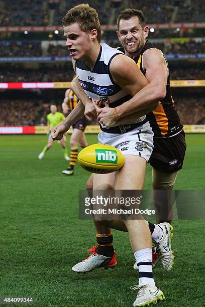 Luke Hodge of the Hawks tackles Jake Kolodjashnij of the Cats during the round 20 AFL match between the Geelong Cats and the Hawthorn Hawks at...