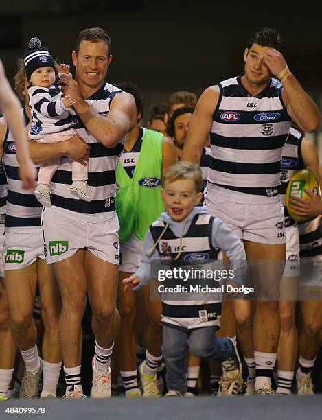 Steve Johnson of the Cats walks out for his 250th game with his kids during the round 20 AFL match between the Geelong Cats and the Hawthorn Hawks at...