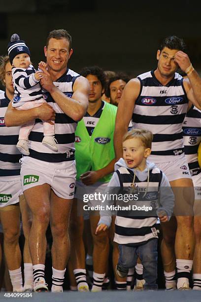 Steve Johnson of the Cats walks out for his 250th game with his kids during the round 20 AFL match between the Geelong Cats and the Hawthorn Hawks at...