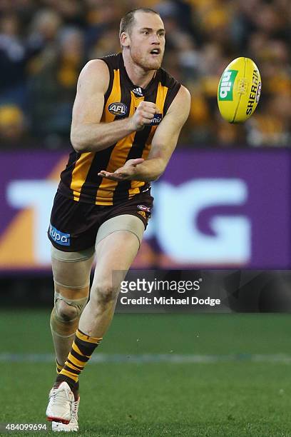 Jarryd Roughead of the Hawks handballs during the round 20 AFL match between the Geelong Cats and the Hawthorn Hawks at Melbourne Cricket Ground on...