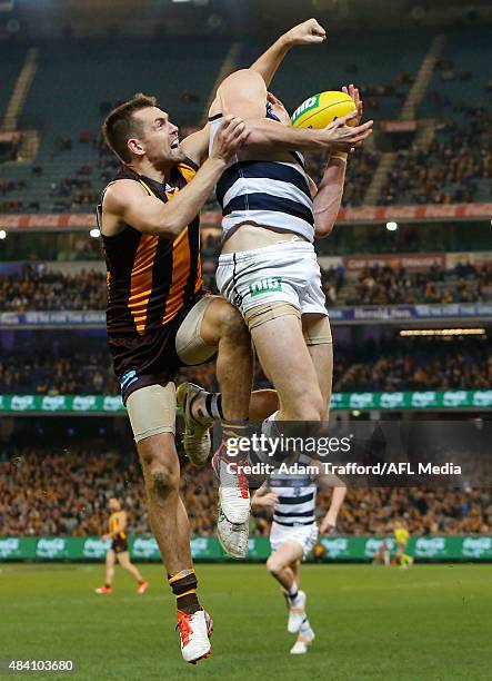 Mark Blicavs of the Cats marks the ball ahead of Luke Hodge of the Hawks during the 2015 AFL round 20 match between the Geelong Cats and the Hawthorn...