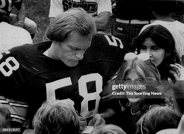 Jack Lambert of the Pittsburgh Steelers signs autographs circa 1970s.