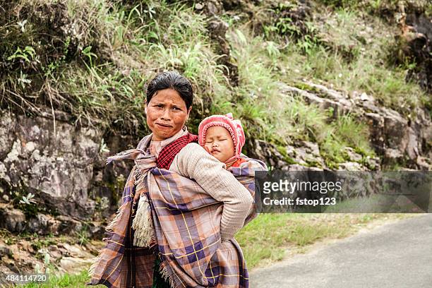 indian woman from the khasi tribe carrying baby down road. - india tribal people stock pictures, royalty-free photos & images