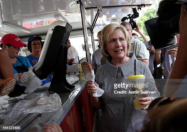 Democratic presidential hopeful and former Secretary of State Hillary Clinton holds a Pork Chop on a Stick and a lemonade as she tours the Iowa State...