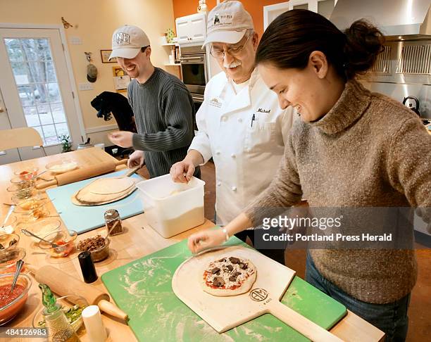 Staff Photo by Derek Davis: Michael Jubinsky helps T.J. McCann and Christine Jamoil of Dover, N.H. Make their pizzas at Stone Turtle Baking and...