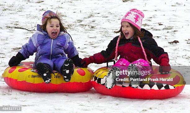Staff Photo by Jill Brady, Sunday, January 18, 2004: Samantha Lockhart and her cousin, Meredith Smith both of Cumberland, share a slick ride on their...