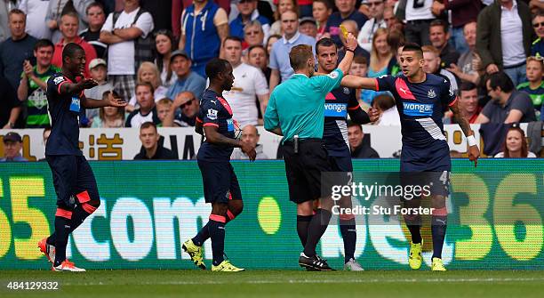 Newcastle striker Aleksandar Mitrovic is booked by referee Michael Jones during the Barclays Premier League match between Swansea City and Newcastle...