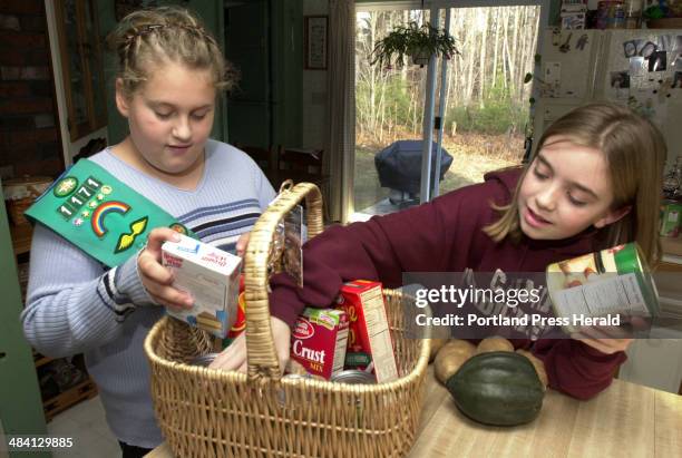 Staff Photo by Jill Brady, Sunday, November 23, 2003: Taylor Hammond, left, and Katie Bennett, both of Girl Scout Junior Troop 1171 in Gorham, pack a...