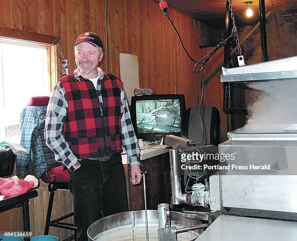 Staff photo by Alan Crowell -- MAKING MAPLE SYRUP: Martin Lariviere monitors the production of maple syrup as sap is boiled down in an evaporator on...