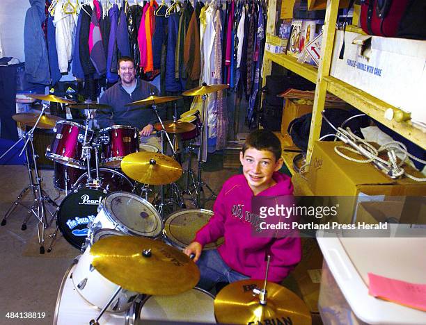 Staff Photo by Gordon Chibroski, Wednesday, December 29, 2004: Doug Doherty and son, Steven enjoy playing their drums in the unfinished storage area...
