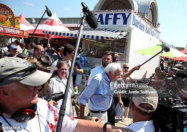 Democratic presidential candidate U.S. Sen. Bernie Sanders is surrounded by media as he drinks a soda while touring the Iowa State Fair on August 15,...