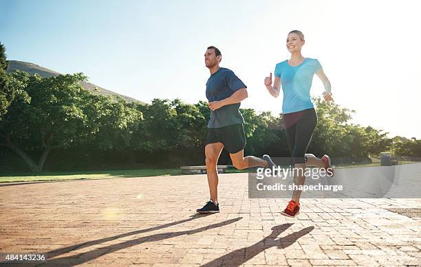 together on the road to fitness - running in park stockfoto's en -beelden