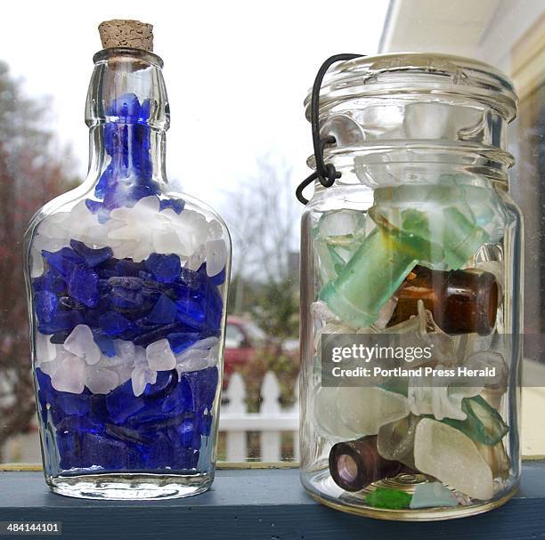 Staff Photo by Gordon Chibroski, Monday, November 22, 2004: An apothecary bottle filled with cobalt blue and frosted white broken sea glass sits next...