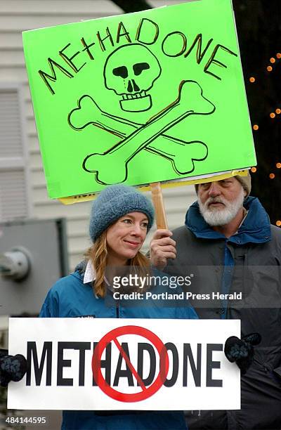 Staff Photo by Shawn Patrick Ouellette, Saturday, December 11, 2004: Angela Pejouhy and her husband Richard Peak hold up signs of protest for a...