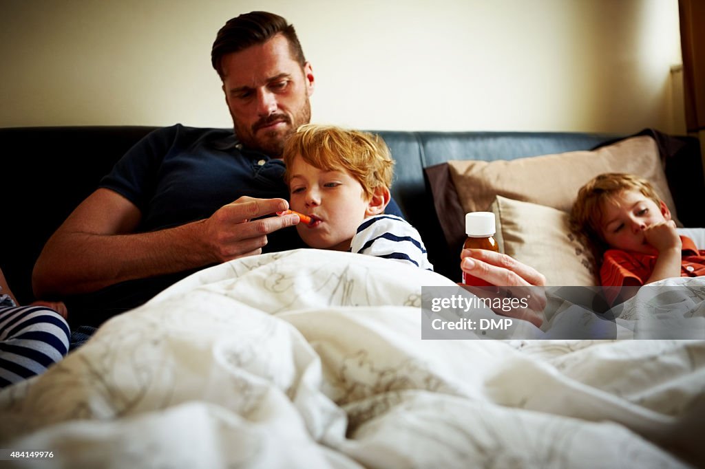 Father measuring temperature of his sick son