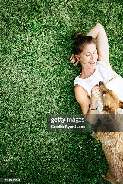 adult woman enjoying time with pet dog - lying down stock pictures, royalty-free photos & images