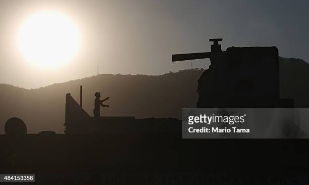 Teen flies a kits atop a partially demolished home in the Vila Autodromo 'favela' community on August 15, 2015 in the Barra da Tijuca neighborhood of...