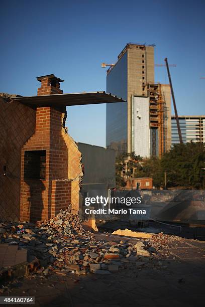 Chimney stands at a partially demolished home in the Vila Autodromo 'favela' community, with Olympic Park construction rising in the background, on...