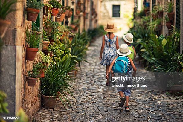 kids walking in mediterranean street. - maiorca 個照片及圖片檔