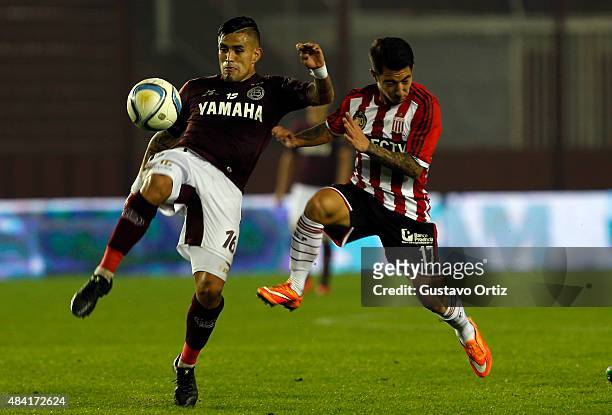 Victor Hugo Ayala of Lanus and Luciano Acosta of Estudiantes jump for the ball during a match between Lanus and Estudiantes as part of 20th round of...