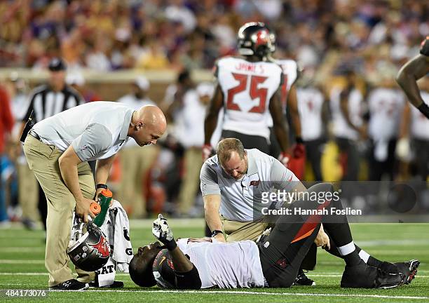 Demar Dotson of the Tampa Bay Buccaneers is looked at by trainers after an injury during the second quarter of the preseason game against the...