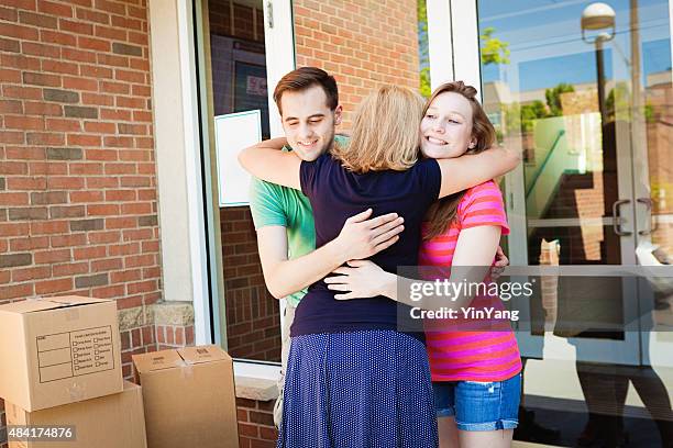 parent saying goodbye to students moving into university dormitory - disembarking stock pictures, royalty-free photos & images