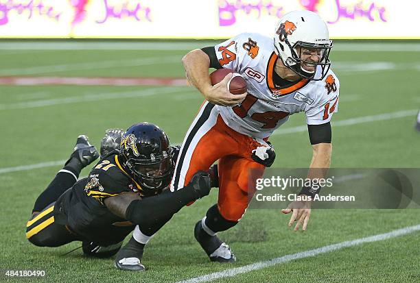 Simoni Lawrence of the Hamilton Tiger-Cats sacks Travis Lulay of the BC Lions during a CFL football game at Tim Hortons Field on August 15, 2015 in...