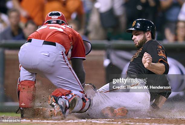 Brandon Belt of the San Francisco Giants scores, sliding under the tag of catcher Jose Lobaton of the Washington Nationals in the bottom of the third...